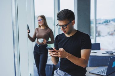 Ellerinde telefonla mutlu bir işadamı, masasında bir öğrenci, bir kafede bir masa, pozitif bir sakin insan, rahatlama, bir hayal, bilgisayardan uzaklaşma, stres hissetme.