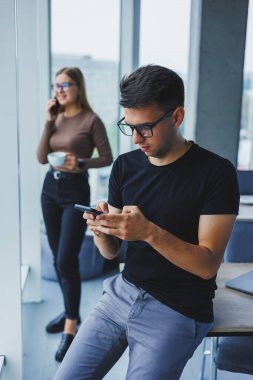 Ellerinde telefonla mutlu bir işadamı, masasında bir öğrenci, bir kafede bir masa, pozitif bir sakin insan, rahatlama, bir hayal, bilgisayardan uzaklaşma, stres hissetme.