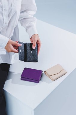 Şık bir kadın elinde siyah deri bir çanta tutuyor. Küçük kadın çantası.