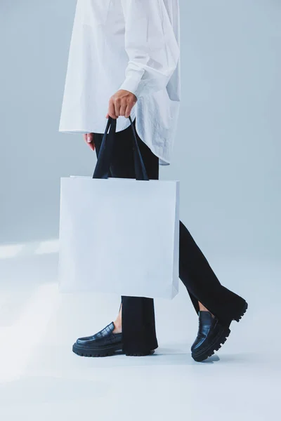 Stylish woman on a white background with a shopping bag. Eco bag for shopping.