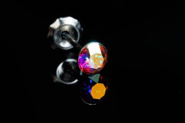 Siyah izole edilmiş arka planda değerli bir taşla gümüş küpeli makro fotoğraf.