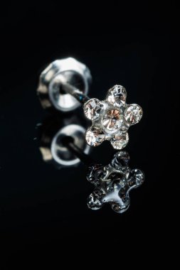 Taş küpeli mücevherler, elmaslı gümüş küpeler, siyah arka planda safir küpeler..