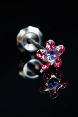 Taş küpeli mücevherler, elmaslı gümüş küpeler, siyah arka planda safir küpeler..