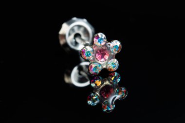 Taş küpeli mücevherler, elmaslı gümüş küpeler, siyah arka planda safir küpeler..