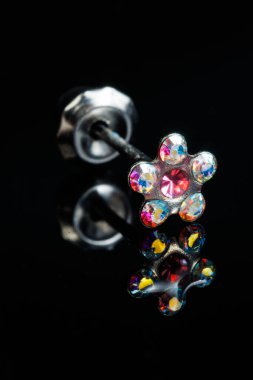 Taş küpeli mücevherler, elmaslı gümüş küpeler, siyah arka planda safir küpeler..