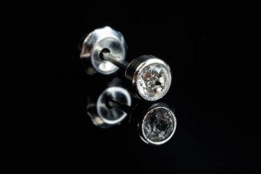 Siyah izole edilmiş arka planda değerli bir taşla gümüş küpeli makro fotoğraf.