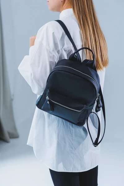 Black leather backpack in a woman\'s hand. A man with a luxurious leather backpack. Women\'s bags