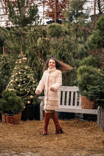 Улыбающаяся Счастливая Кудрявая Женщина Шубе Кружит Среди Рождественских Елок Улице — стоковое фото