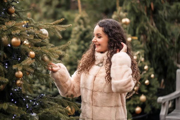 Lachende Vrolijke Krullende Vrouw Een Bontjas Slentert Door Kerstmarkt Wachten — Stockfoto