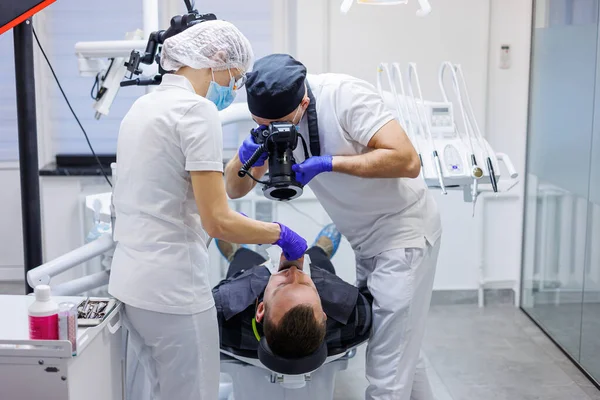 Young Dentist Takes Picture Patient Teeth Assistant Helps Doctor Dental — Stock Photo, Image