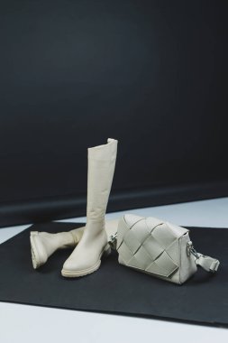 Deri bir çantayla arka planda kadın deri botları. Yeni kadın kış ayakkabıları koleksiyonu.