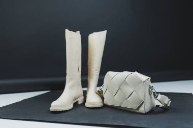 Deri bir çantayla arka planda kadın deri botları. Yeni kadın kış ayakkabıları koleksiyonu.