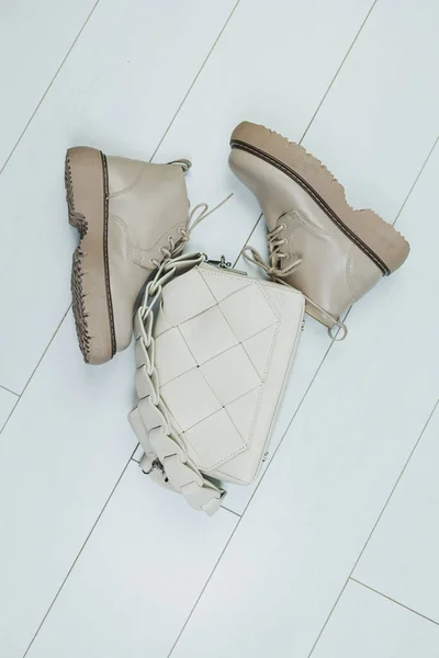 Women's leather boots on a plain background with a leather bag. New collection of women's winter shoes.