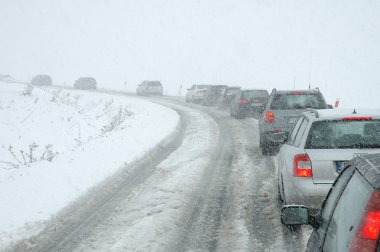 Traffic jam in heavy snowfall on mountain road clipart