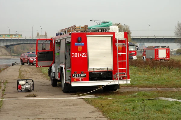 Fire brigade exercises on river bank — Stock Photo, Image