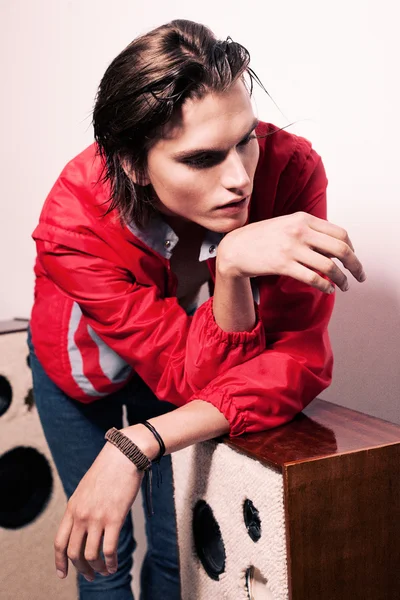 Young man with his hands on speakers looking down — Stock Photo, Image