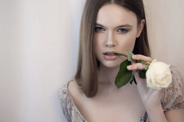 Mujer joven con rosa blanca en la boca —  Fotos de Stock