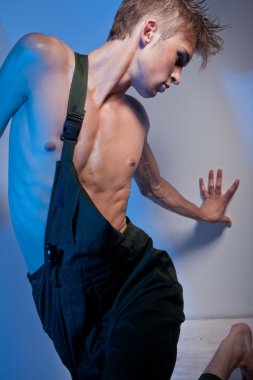 Young man in coveralls looking back