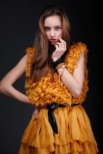 Aantrekkelijke vrouw in gele jurk met hand in de buurt van haar gezicht — Stockfoto