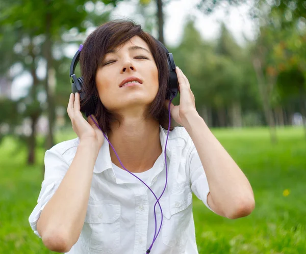 Vrouw luisteren muziek over de aard — Stockfoto