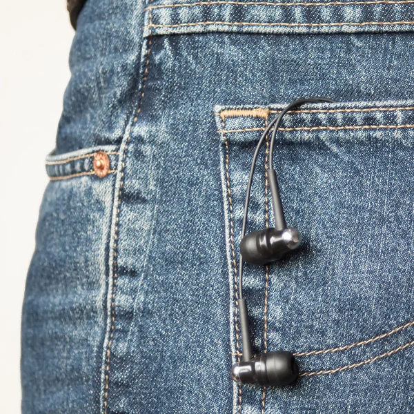 Ear phones hanging out of pocket — Stock Photo, Image