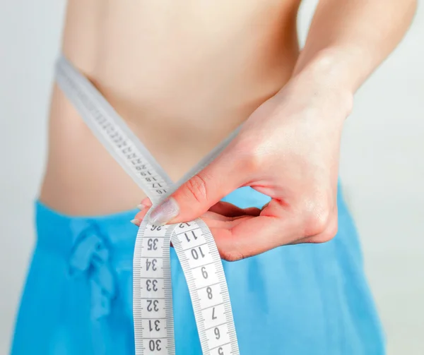 Young woman measuring body — Stock Photo, Image