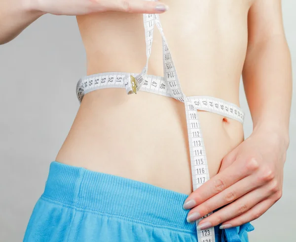 Young woman measuring body — Stock Photo, Image