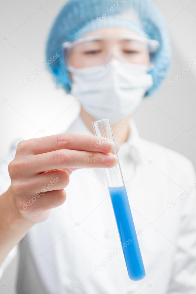 Lab technician holding a test tube close up