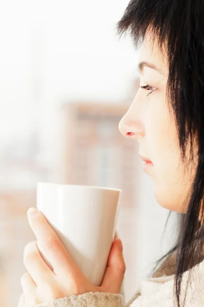 Mujer con una taza mirando por la ventana —  Fotos de Stock