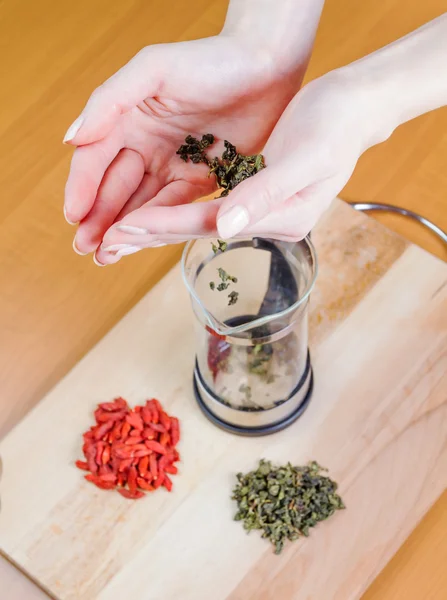 Mujer esparciendo té verde — Foto de Stock