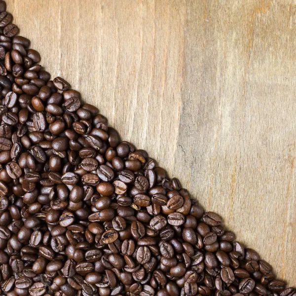 Grano de café sobre fondo de madera — Foto de Stock