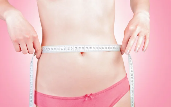 신체를 측정 하는 젊은 여자 — 스톡 사진