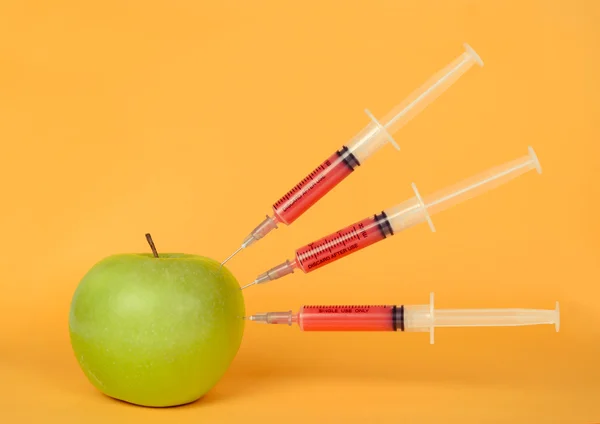 Green apple and syringe — Stock Photo, Image
