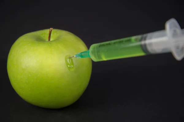 Injection green liquid into apple — Stock Photo, Image