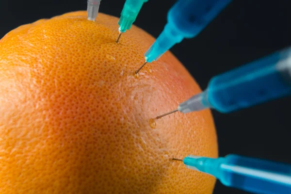 Grapefruit with syringes, close-up — Stock Photo, Image