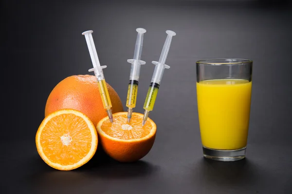 Oranje met vitaminen in de spuit — Stockfoto