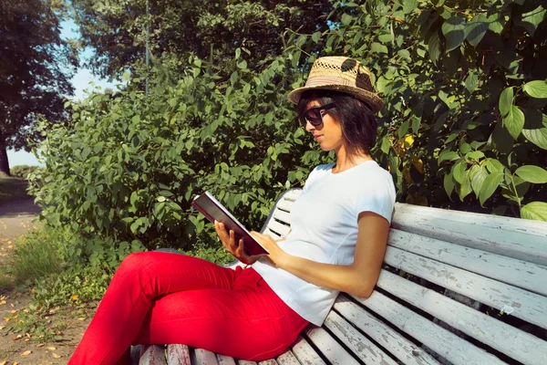 Femme lit un livre sur un banc — Photo