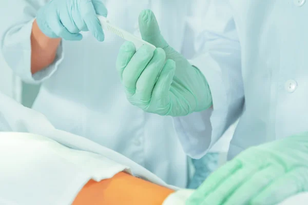 Assistant passes a scalpel — Stock Photo, Image