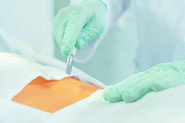 Doctor cuts with a scalpel — Stock Photo, Image