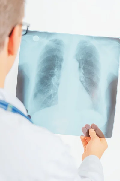Doctor looks at x-ray picture — Stock Photo, Image