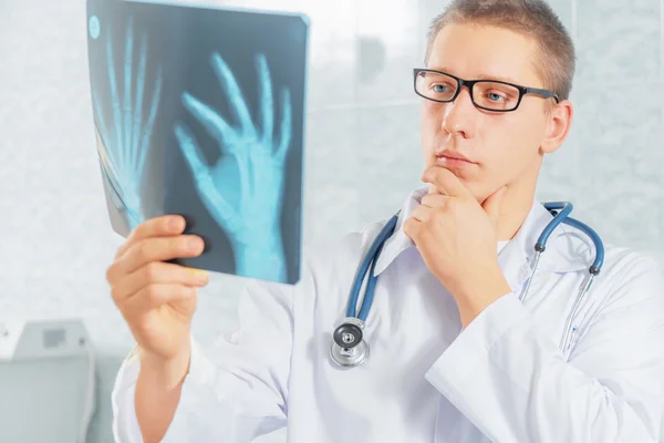 Physician looks at x-ray image — Stock Photo, Image