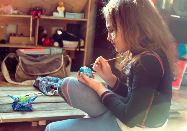 Little girl paints egg for Easter day — Stock Photo, Image