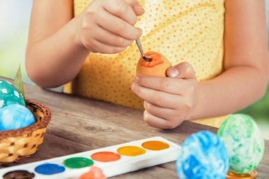 Kız Paskalya yumurtası turuncu renkte boyar.