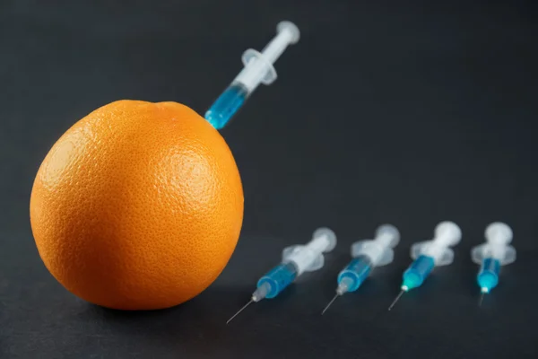 Syringes injected into grapefruit — Stock Photo, Image