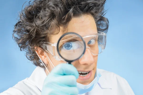 Doctor looks through a magnifying glass — Stock Photo, Image