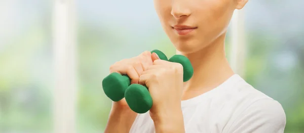 Smiling woman with green dumbbell — Stock Photo, Image