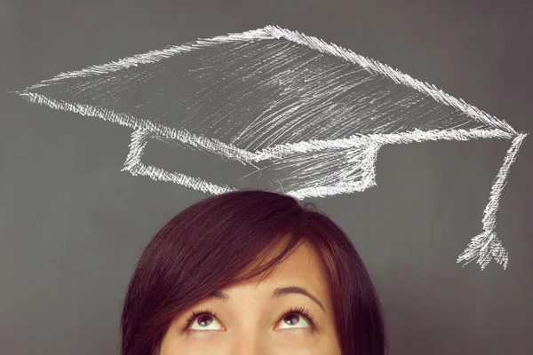 Donna alza lo sguardo sul disegno cappello educativo — Foto Stock