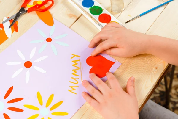 Child glues paper heart — Stock Photo, Image