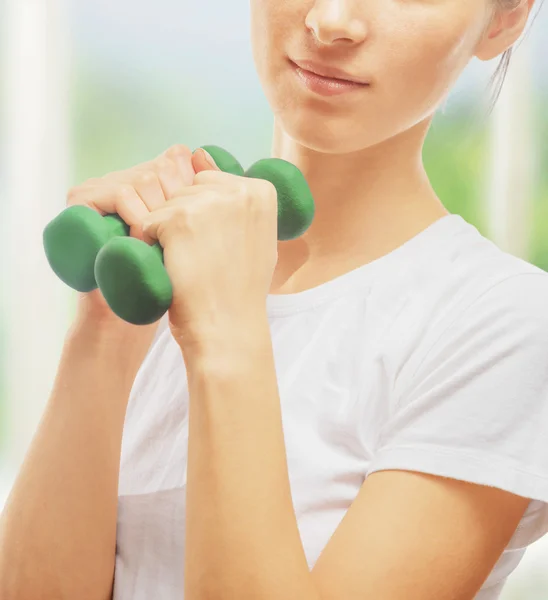 Woman is doing exercises with dumbbells — Stock Photo, Image