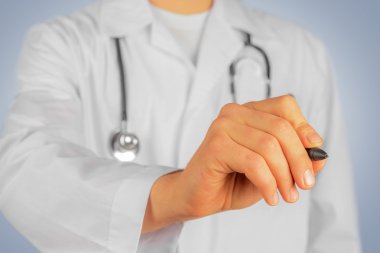 Doktor kalemi ile bir şey havada yazıyor.